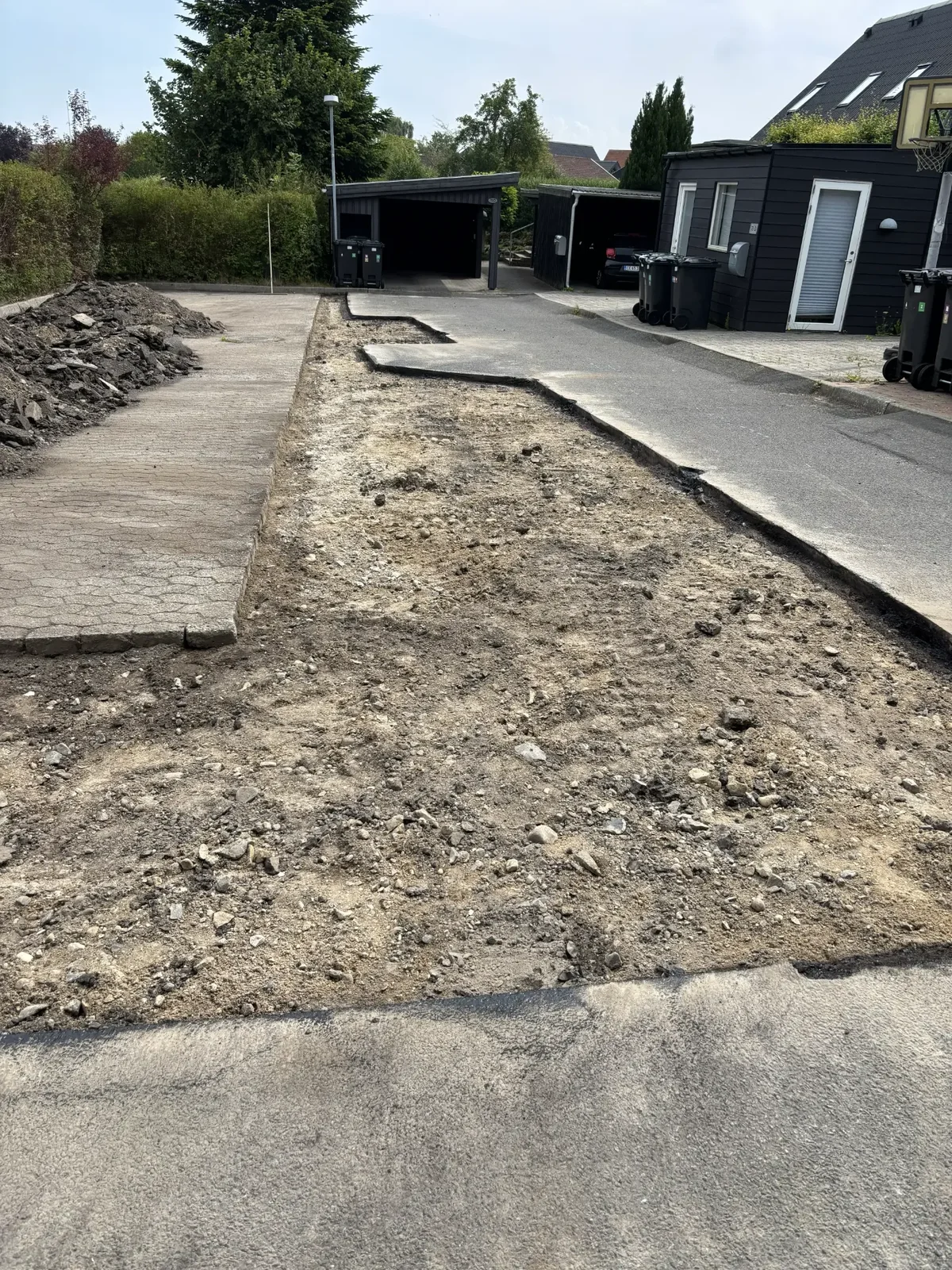 Opbrudt vej ned til bærelag af grus og sten i villakvarter