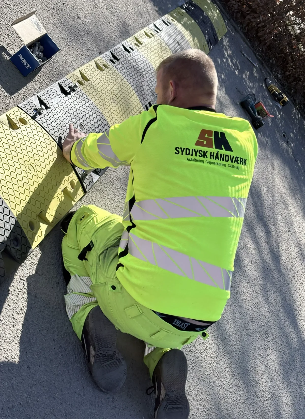 Medarbejder fra Sydjysk Håndværk monterer et vejbump