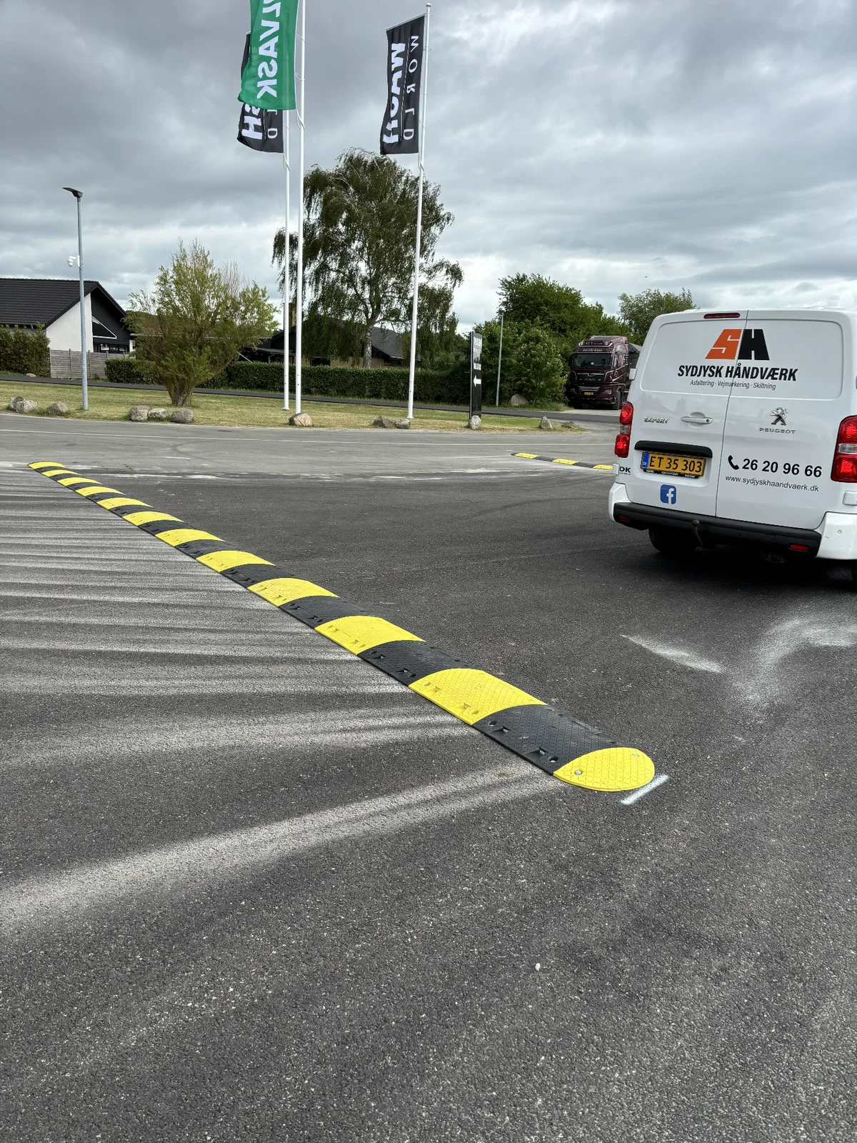 Langt gult og sort vejbump med varevogn