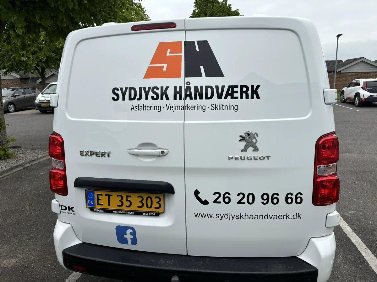 Bagenden af Sydjysk Håndværks varevogn med logo og kontaktoplysninger